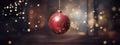 Red Christmas glass ball hanging on blurred dark snowy background with bokeh golden lights. Royalty Free Stock Photo