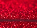 Red christmas glitter background with stars. Festive glowing blurred texture