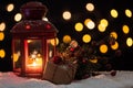 Lit Christmas lanter on black background with blurred lights
