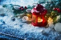 Red Christmas lantern in snow with fir tree branch. Winter cozy scene