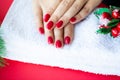 Red Christmas manicure make in beauty studio on Christmas background Royalty Free Stock Photo