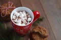 Red Christmas mug of coffee and marshmallows and cookies on the wooden table Royalty Free Stock Photo