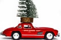 Red Christmas or New Year card with a festive car toy and a tree on a car crash. Royalty Free Stock Photo