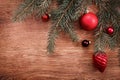 Red Christmas ornaments and fir tree branch on a rustic wooden background. Xmas card. Happy New Year. Top view Royalty Free Stock Photo