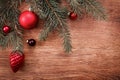 Red Christmas ornaments and fir tree branch on a rustic wooden background. Xmas card. Happy New Year. Top view Royalty Free Stock Photo