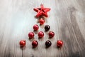 Red Christmas ornaments in the form of a Xmas tree on a rustic wooden background. Merry christmas card. Happy New Year Royalty Free Stock Photo