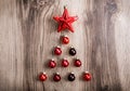 Red Christmas ornaments in the form of a Xmas tree on a rustic wooden background. Merry christmas card. Happy New Year Royalty Free Stock Photo