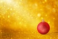 Red Christmas ornaments on golden holiday background with twinkle bokeh light.