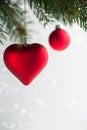 Red christmas ornaments heart and ball on the xmas tree on glitter bokeh background. Royalty Free Stock Photo