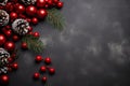 Red Christmas ornaments, holly berries, cones and fir tree branches on dark wooden table. Christmas flat lay background with copy Royalty Free Stock Photo