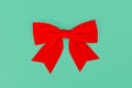 Red Christmas satin ribbon on green background