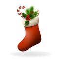 Red Christmas sock with holly berries, candy and fir branch. Xmas greeting card Royalty Free Stock Photo
