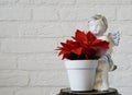Red christmas star flower in a angel flowerpot in closeup and brick wall background Royalty Free Stock Photo