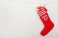 Red Christmas stocking full of gifts hanging on brick wall, space for text. Royalty Free Stock Photo