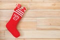 Red Christmas stocking full of gifts hanging on wooden wall, space for text. Royalty Free Stock Photo