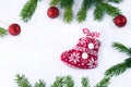 Red Christmas stocking sock and decoration balls on white background, frame of green fir tree branches Royalty Free Stock Photo