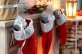 Red Christmas stockings with gifts on decorative fireplace indoors Royalty Free Stock Photo