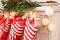 Red Christmas stockings hanging on decorated fireplace, indoors. Royalty Free Stock Photo