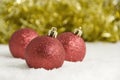 Red Christmas Tree Decorations and Gold Tinsel in Snow