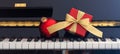Red Chritmas ball and gift box on piano keyboard, front view Royalty Free Stock Photo