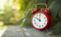 Red classic alarm clock in the garden, save time, daylight saving concept Royalty Free Stock Photo