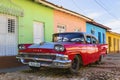 Red classic American car and colorful colonial buildings of Trinidad