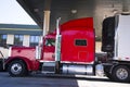 Red classic big rig semi truck and reefer trailer