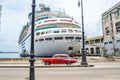 Red classic car passing cruise ship in Cuba Royalty Free Stock Photo