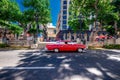 Red vintage 1958 Chevy in Havana on Prado Avenue people on the background selling during the day