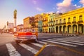 Red classic convertible car and colorful buildings in downtown Havana