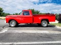 Red classic 1955 Ford F-100 Pickup Truck. Parked in a parking lot next to an apartment building Royalty Free Stock Photo