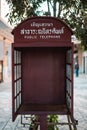 Red classic public telephone box stands isolated in an urban environment in Thailand, Asia