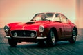 a classic red sports car on a wooden floor with white walls Royalty Free Stock Photo