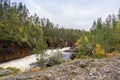 Red cliff, stone wall, forest, waterfall and wild river view in autumn Royalty Free Stock Photo