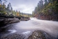 Red cliff, stone wall, forest, waterfall and wild river view in autumn Royalty Free Stock Photo