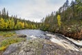 Red cliff, stone wall, forest, waterfall and wild river view in autumn Royalty Free Stock Photo