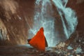 Red cloaked figure in front of a mighty waterfall Royalty Free Stock Photo