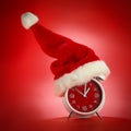 Red clock with Christmas Santa hat. Time for Christmas shopping. Royalty Free Stock Photo