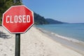 Red closed sign on beach background. COVID 19 pandemic quarantine. Cancelled vacation, travel, holiday plans because of corona Royalty Free Stock Photo