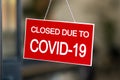 Red closed sign due to Covid-19 on shop window Royalty Free Stock Photo