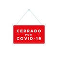 Red closed sign with the text: Closed due to Covid-19 in Spanish. Cerrado por Covid-19. Coronavirus crisis