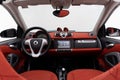 Full view of a Smart ForTwo dashboard in red cloth with silver accents, Studio, white background