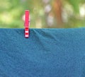 Red clothespin fixes fabric on the clothesline