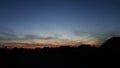 Red clouds and a piece of blue sky over the roofs of the houses. Silhouette and stanchion on roof houses sunset time sky Royalty Free Stock Photo