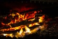 Red coals with fire on black background. Burning coals and wood in fire. Burning wood to keep warm and heat. Glowing embers in hot Royalty Free Stock Photo