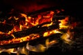 Red coals with fire on black background. Burning coals and wood in fire. Burning wood to keep warm and heat. Glowing embers in hot Royalty Free Stock Photo