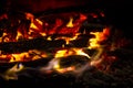 Red coals with fire on black background. Burning coals and wood in fire. Burning wood to keep warm and heat. Glowing embers in hot Royalty Free Stock Photo