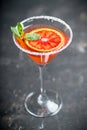 Red cocktail with bloody oranges in martini glass on the rustic background Royalty Free Stock Photo