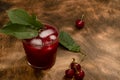 Red cocktail. Cherry juice with ice. Cherry leaves and cherry berries. The summer aroma of coolness in a glass. Juccy Royalty Free Stock Photo