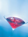 Red cocktail drink with ice cubes on blue light tint background, fun and dance disco Royalty Free Stock Photo
